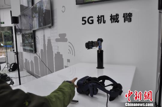 通过5G网络，机械臂可以对外界信息及时反馈。图为体验者与机械臂玩石头剪子布游戏。　陈茂霖 摄